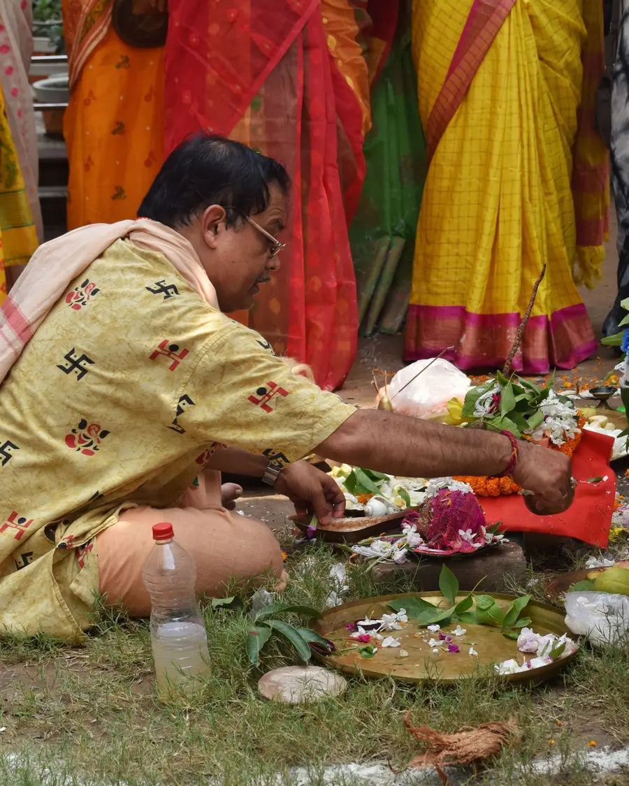 A priest performing puja on the ground, like a bhoomi pujan